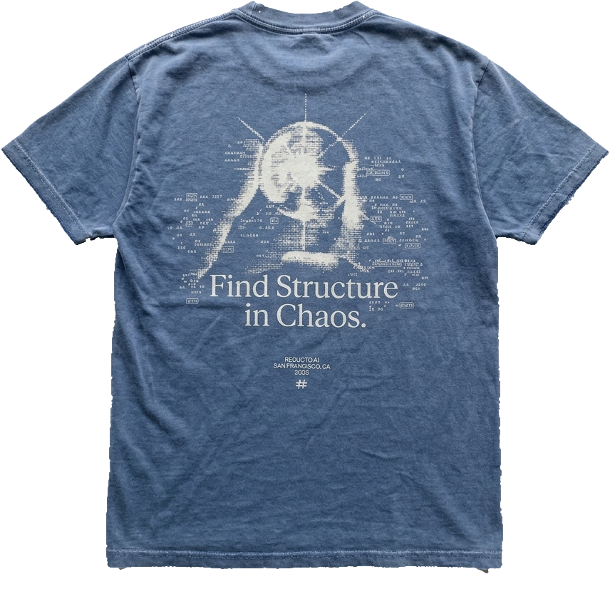 The reducto Drop 001 t-shirt from the back: washed blue cotton with a cream halftone print of a glowing figure, scattered tiny text, and the line Find Structure in Chaos.